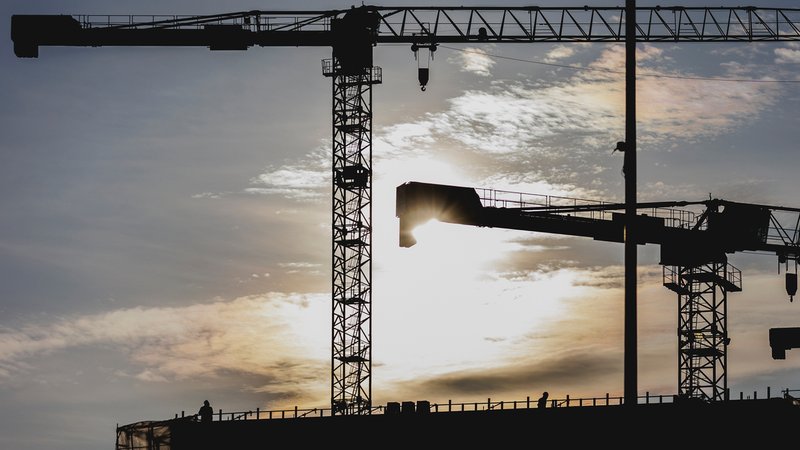 Bauarbeiter auf einem Baugerüst, im Hintergrund Kräne (Symbolbild) | Bild: picture alliance / photothek.de|Florian Gaertner Bauarbeiter auf einem Baugerüst, im Hintergrund Kräne (Symbolbild)