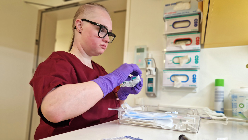 Anna Lena Bogenhauser ist 30 Jahre alt, hat das Down-Syndrom und arbeitet als Pflegehelferin in der Notaufnahme des Uniklinikums in Augsburg. | Bild: BR/Julia Grantner Anna Lena Bogenhauser ist 30 Jahre alt, hat das Down-Syndrom und arbeitet als Pflegehelferin in der Notaufnahme des Uniklinikums in Augsburg.