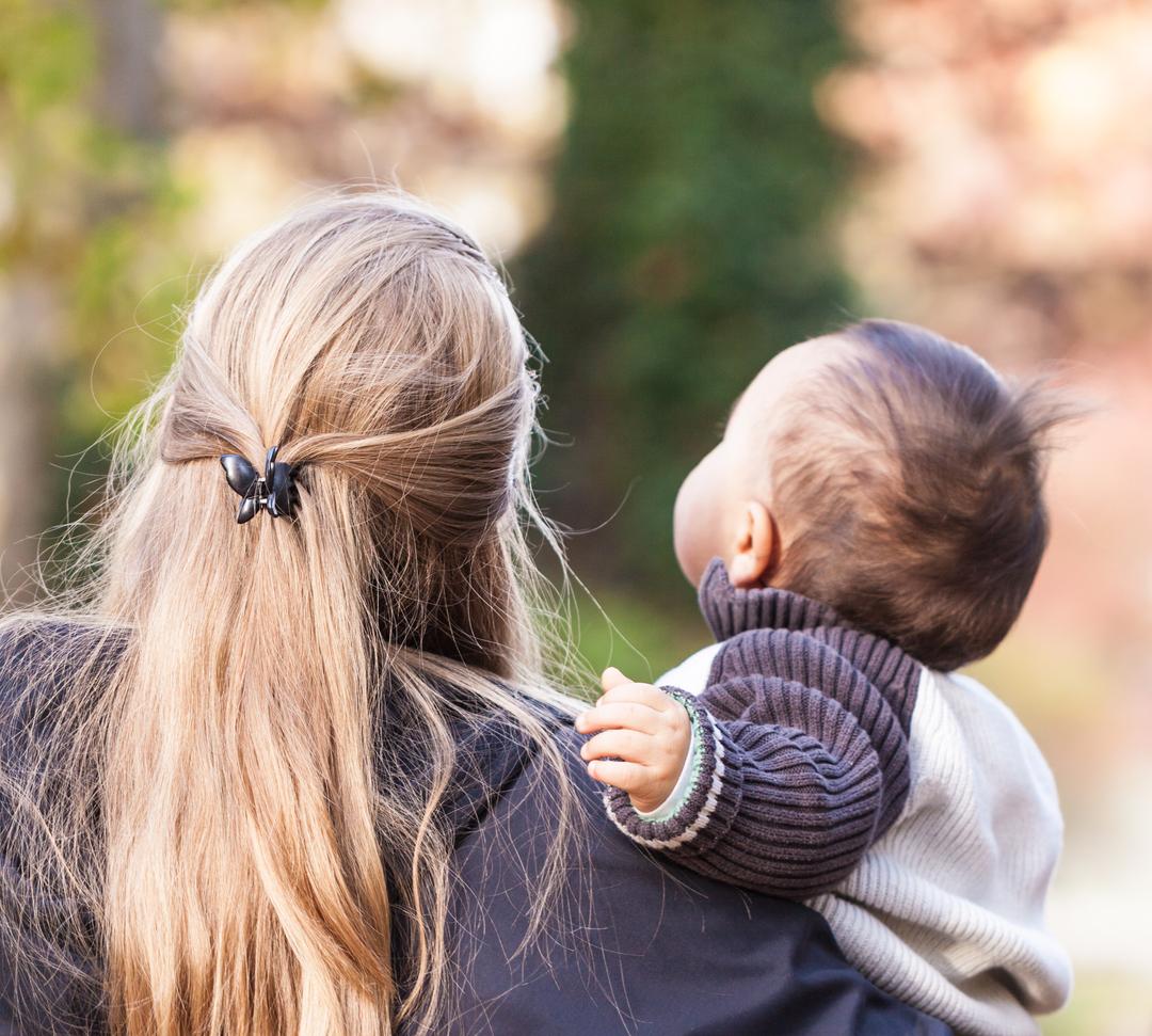 Eine Mutter hält ihr Baby auf dem Arm.