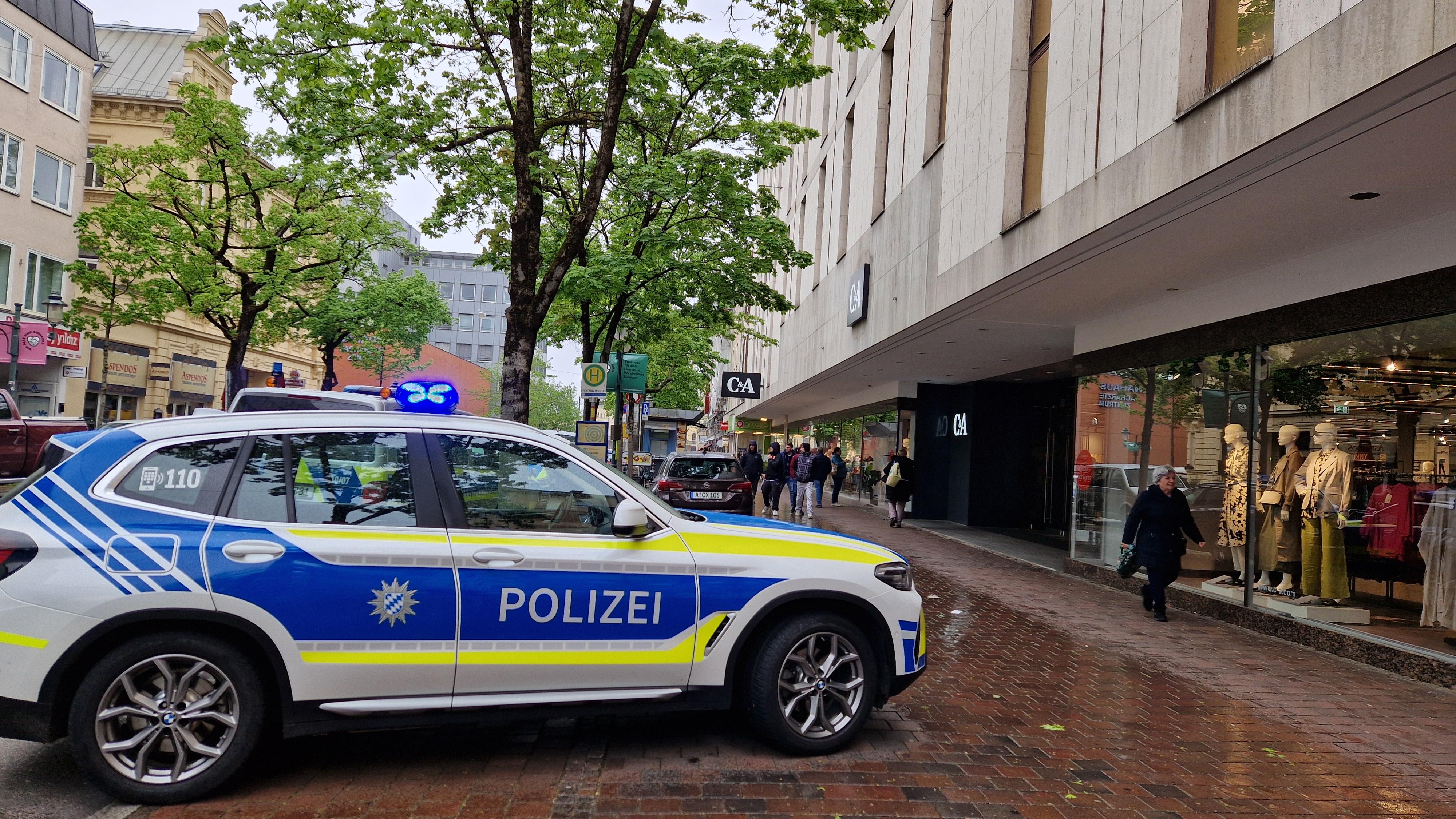 Ein Polizeiwagen steht mit eingeschaltetem Blaulicht in der Augsburger Innenstadt. Innerhalb kürzester Zeit wurden mehrere Brände in Einkaufläden gelegt.