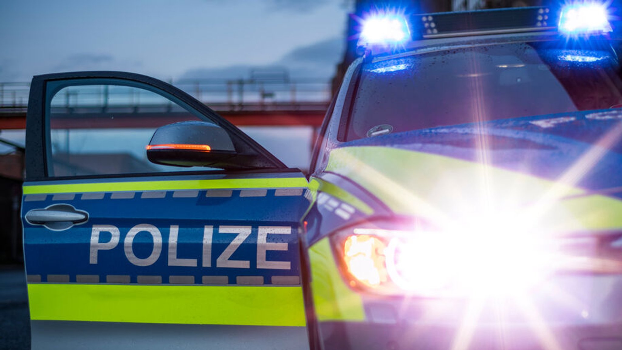 Polizei im Einsatz: Polizeiauto mit Blaulicht und geöffneter Beifahrertür.