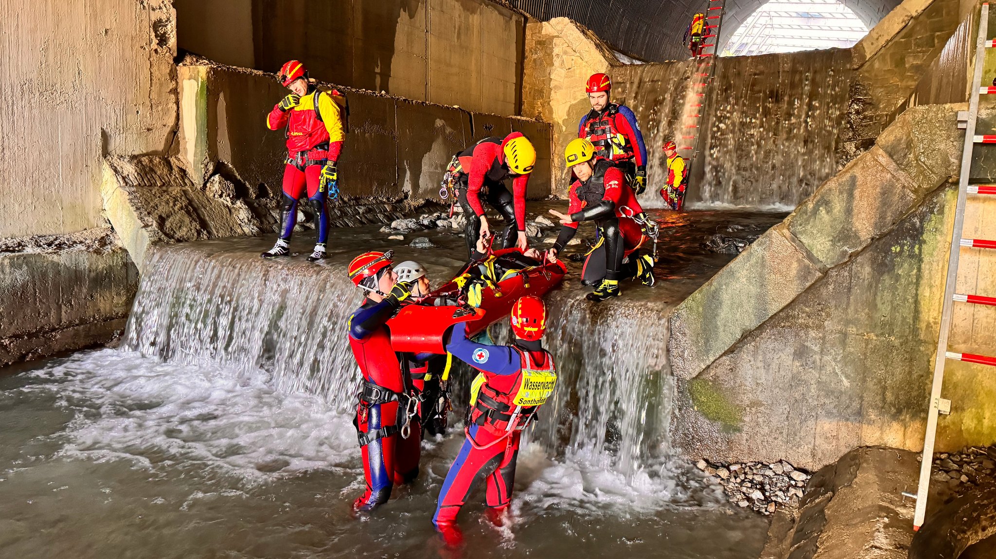 Rettungskräfte der ehrenamtlichen Wasserrettung üben an einem unterirdischen Bachlauf, wie man eine verletzte Person richtig bergen kann. | Bild: DLRG Füssen/Krahmer Rettungskräfte der ehrenamtlichen Wasserrettung üben an einem unterirdischen Bachlauf, wie man eine verletzte Person richtig bergen kann.