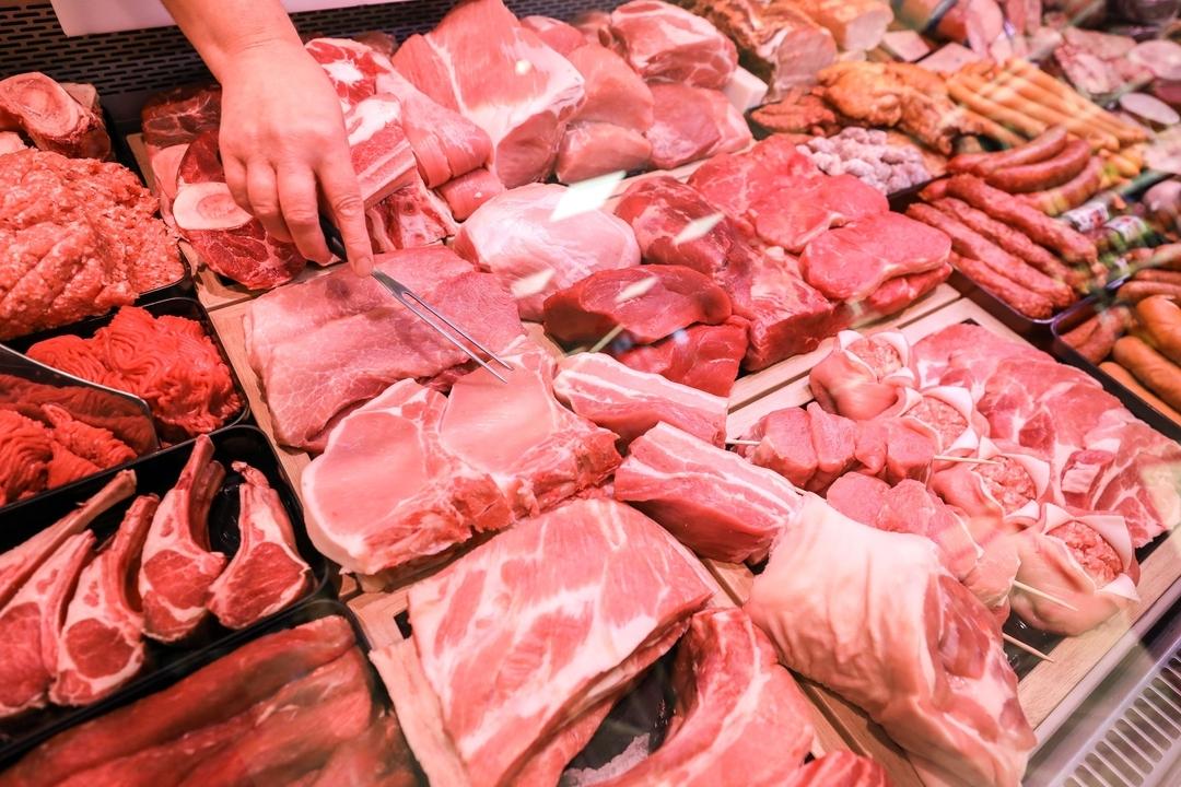 Verschiedene Sorten Schweinefleisch und Rindfleisch liegen in einer Fleischtheke in einem Supermarkt.