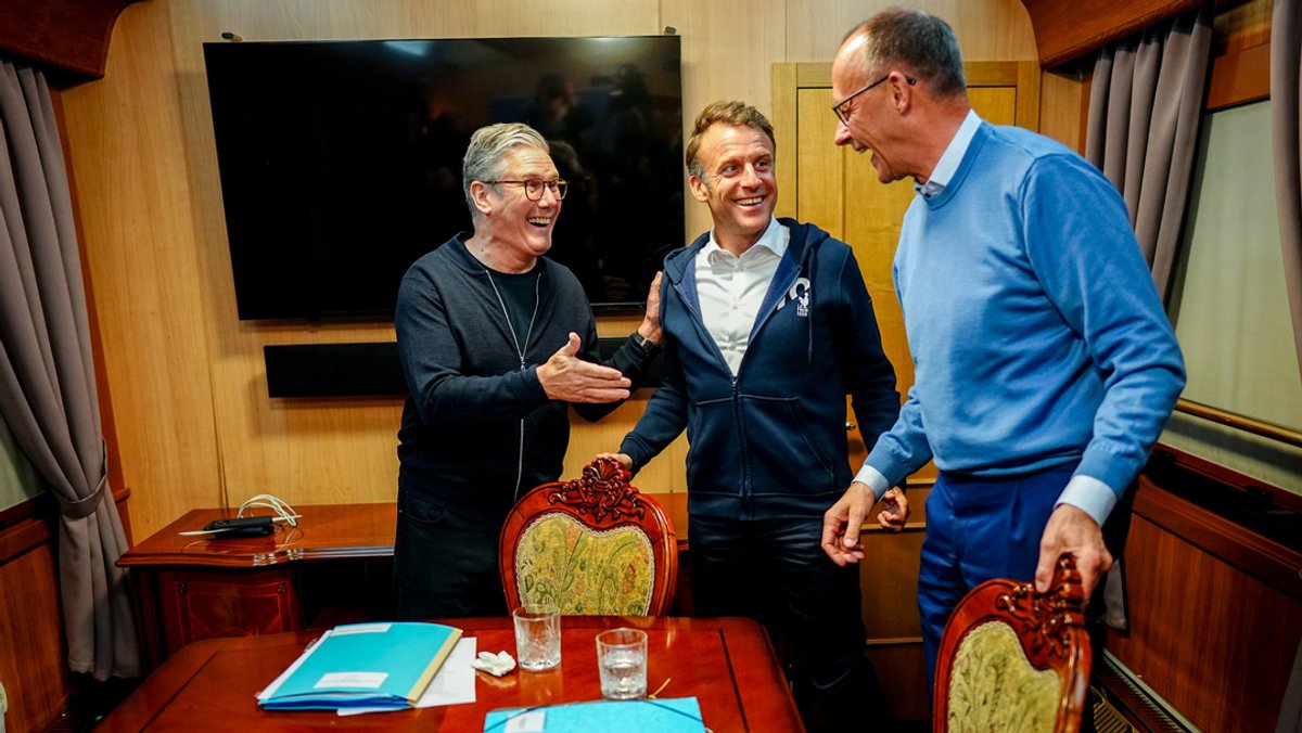 09.05.2025, Polen, Przemysl: Bundeskanzler Friedrich Merz (r, CDU), Keir Starmer (l), Premierminister von Großbritannien, und Frankreichs Präsident Emmanuel Macron stehen im Salonwagen des Sonderzugs nach Kiew zusammen.