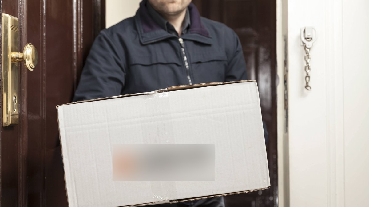Paketbote übergibt ein Paket (Symbolbild)