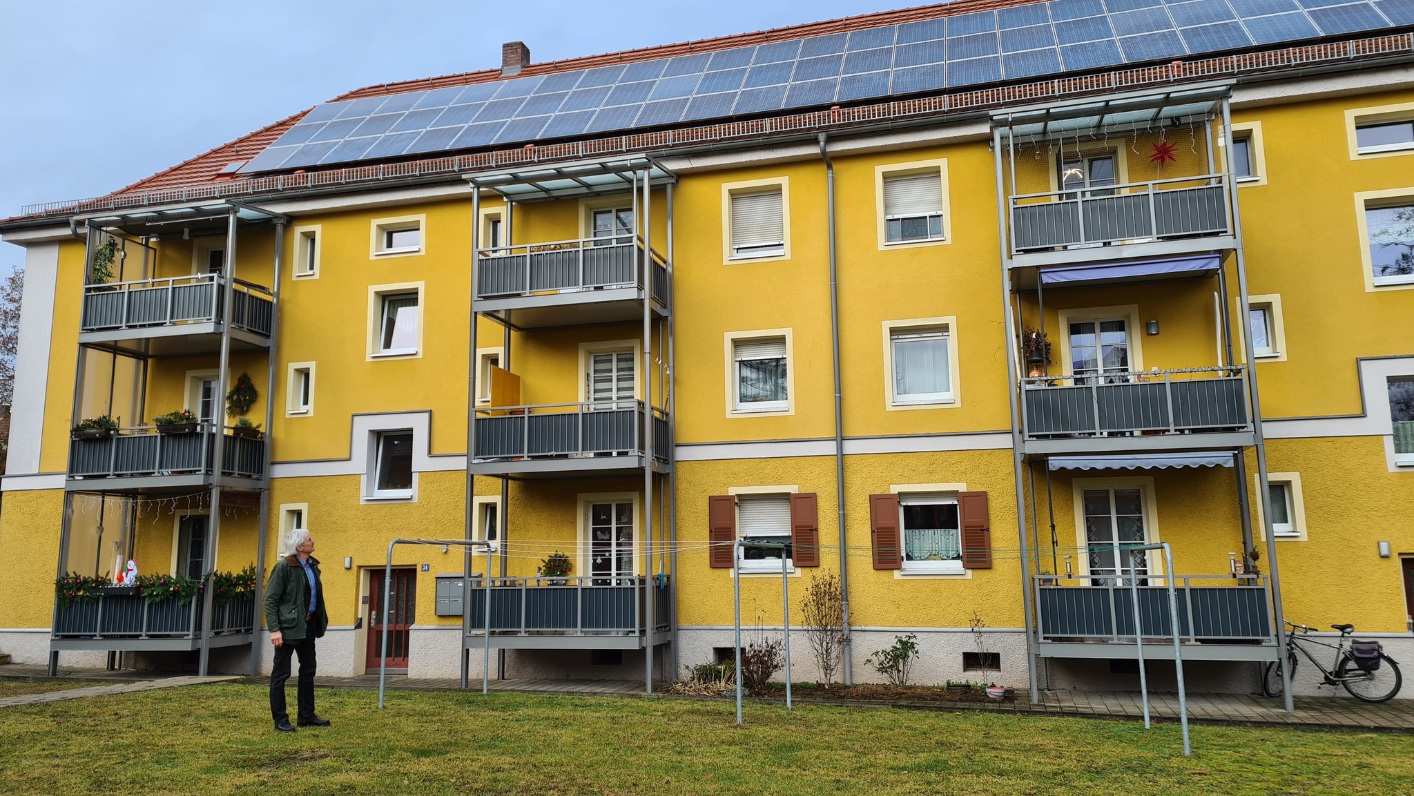 Richard Mergner, Landesvorstand Bund Naturschutz Bayern vor der energetisch sanierten Bauernfeindsiedlung in Nürnberg