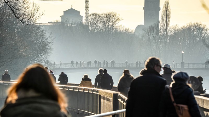 Winterlicht gekleidete Menschen laufen über eine Brücke in einem Park, im Hintergrund scheint die Sonne und es zieht Nebel vom Fluss darunter auf. | Bild: picture alliance / Wolfgang Maria Weber | Wolfgang Maria Weber Winterlicht gekleidete Menschen laufen über eine Brücke in einem Park, im Hintergrund scheint die Sonne und es zieht Nebel vom Fluss darunter auf.