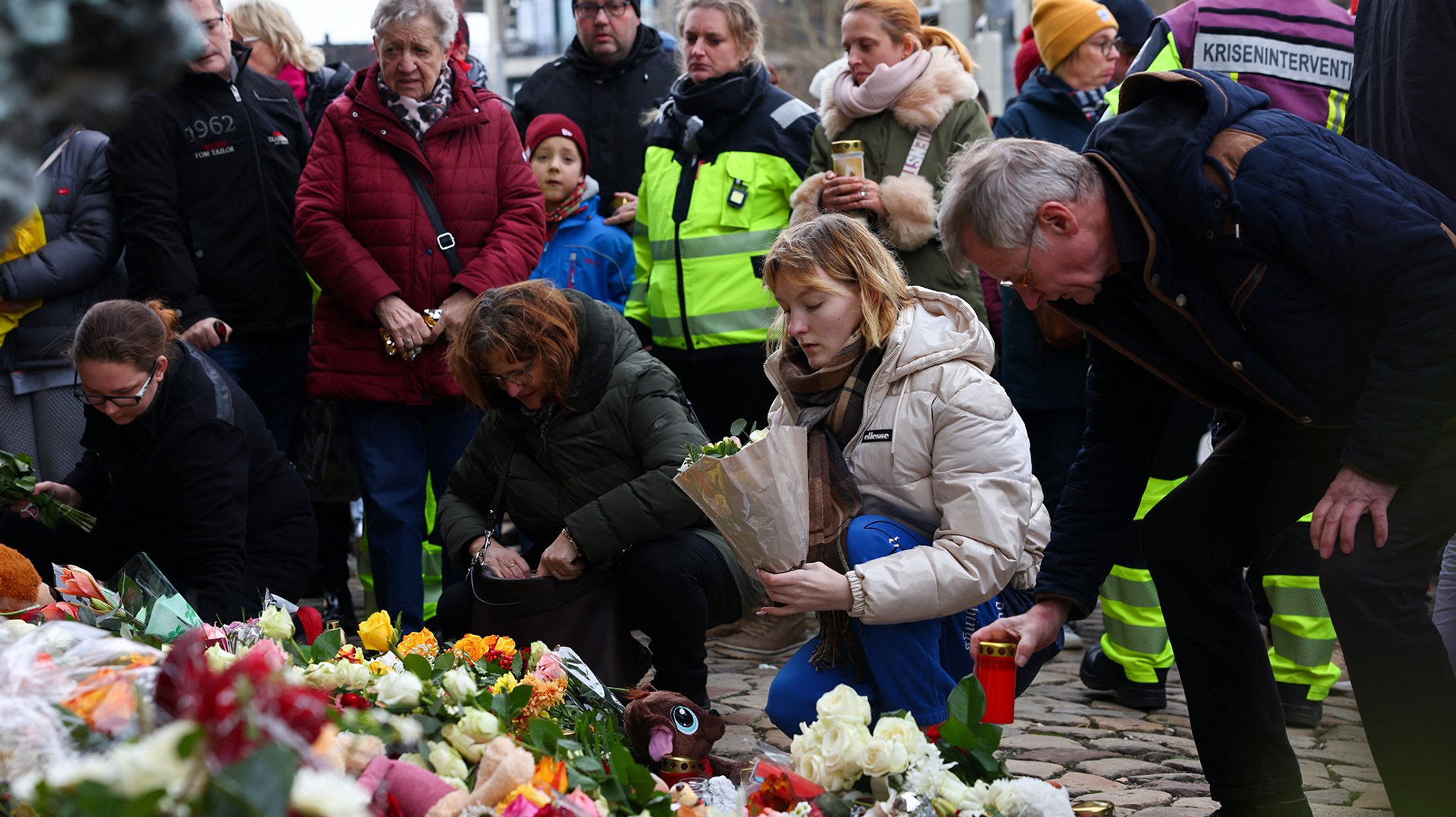 Menschen legen in Magdeburg Blumen nieder. Nach dem Anschlag auf den Magdeburger Weihnachtsmarkt ist die Zahl der Todesopfer auf fünf gestiegen. Mehr als 200 Menschen wurden verletzt.