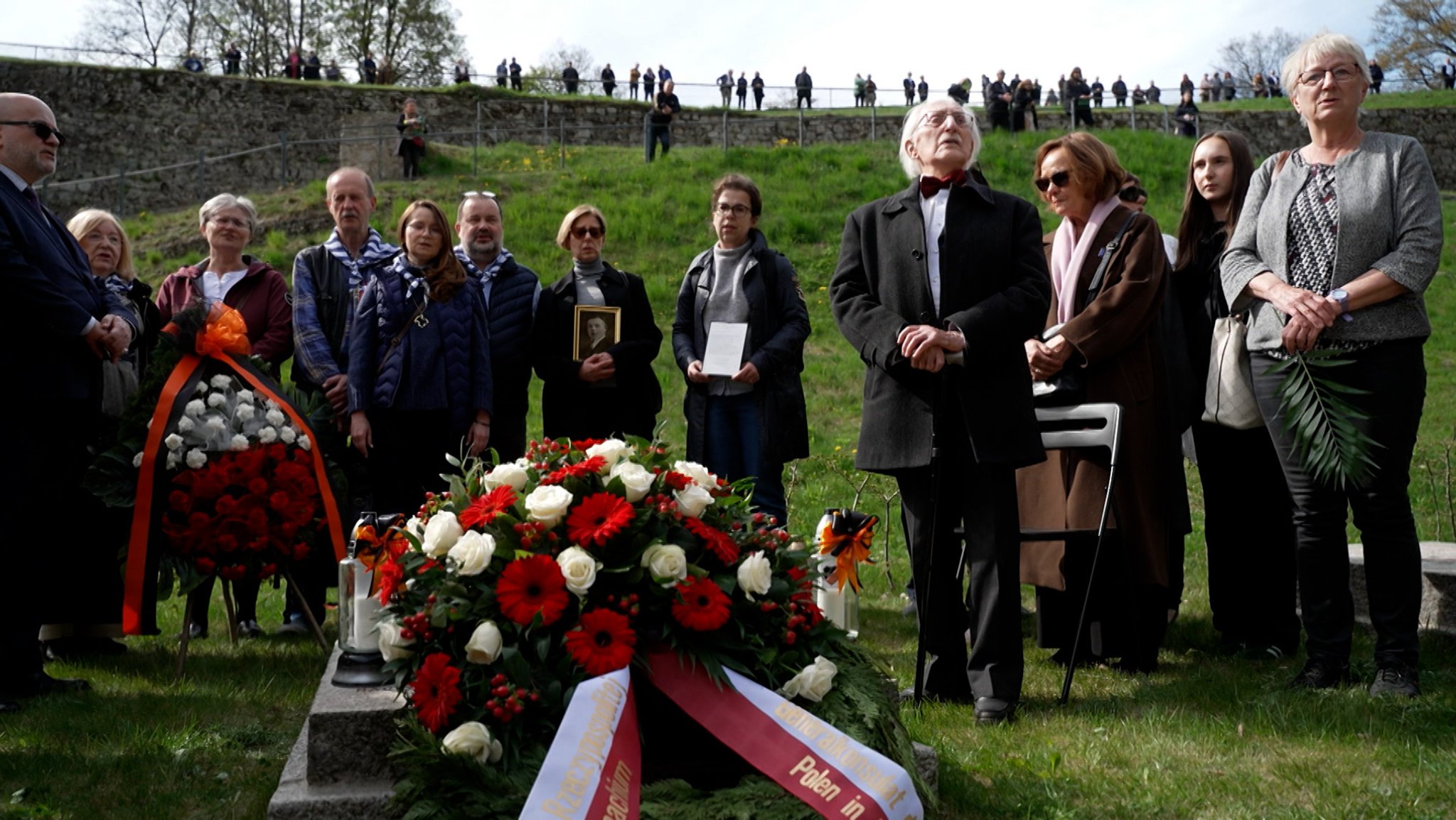 Menschen beim Gedenken an das Leid im ehemaligen KZ Flossenbürg.