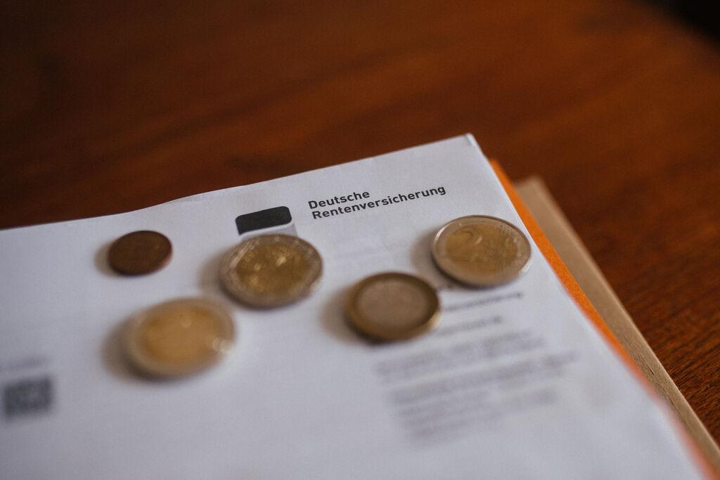 Ein Brief der Deutschen Rentenversicherung in einem Ordner mit Geld.