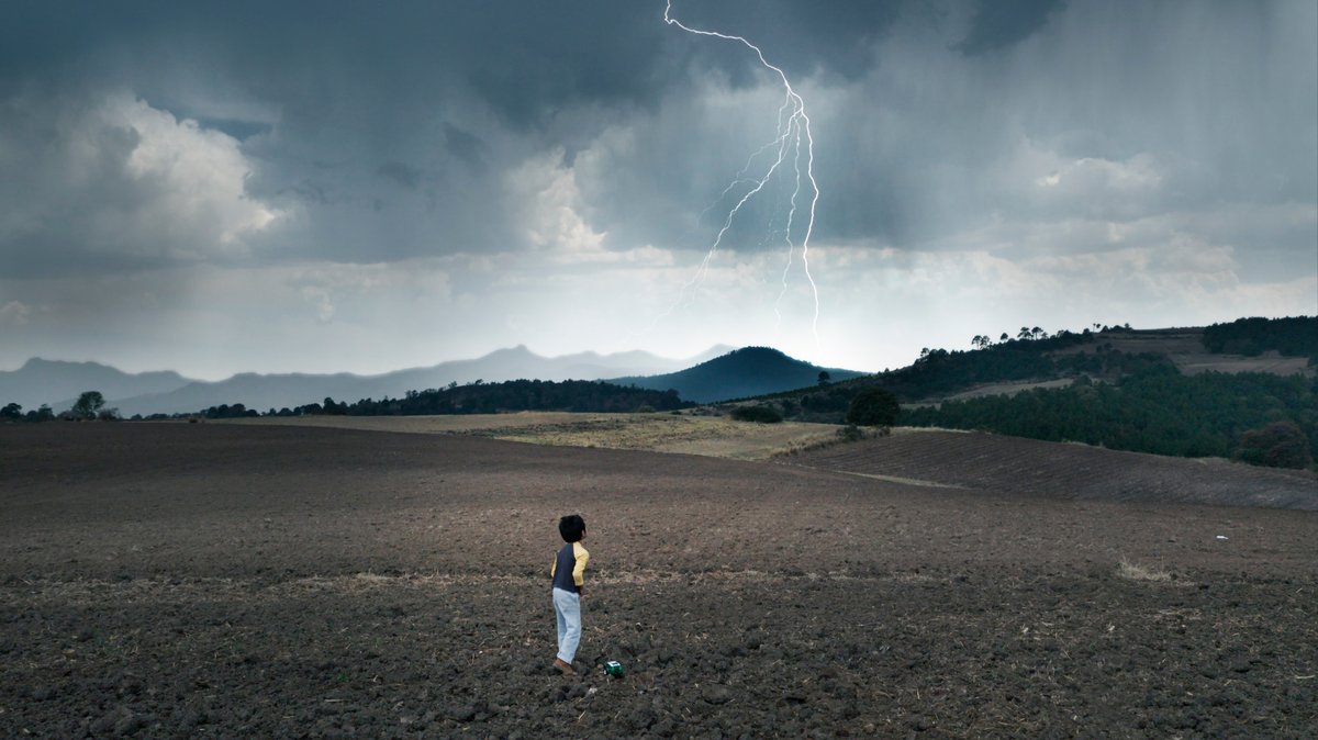 Ein Kind steht vor einer Landschaft