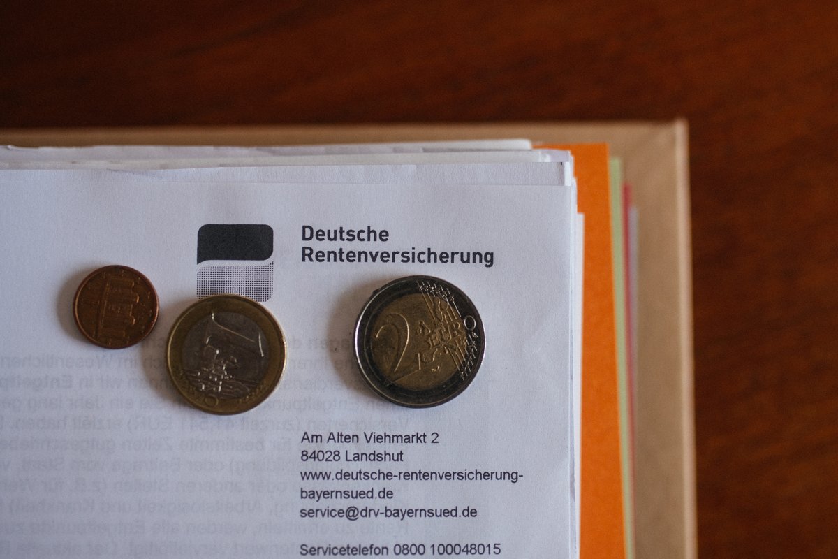 Ein Brief der Deutschen Rentenversicherung in einem Ordner mit Geld.