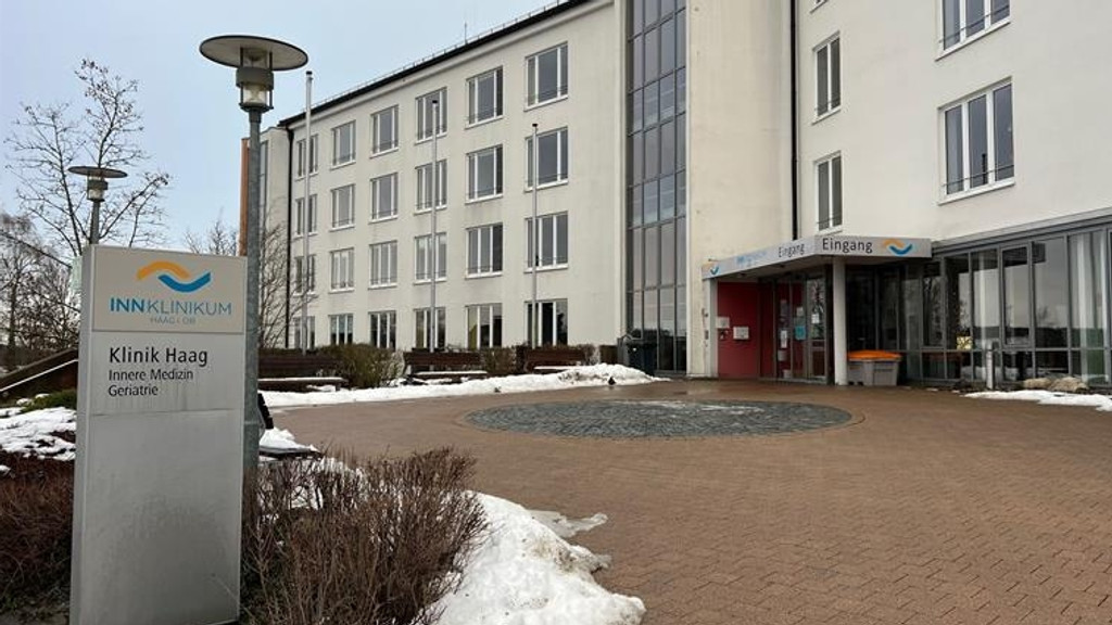 InnKlinikum Haag - ein weißes dreistöckiges Gebäude mit großen Fenstern, Platz vor dem Eingang
