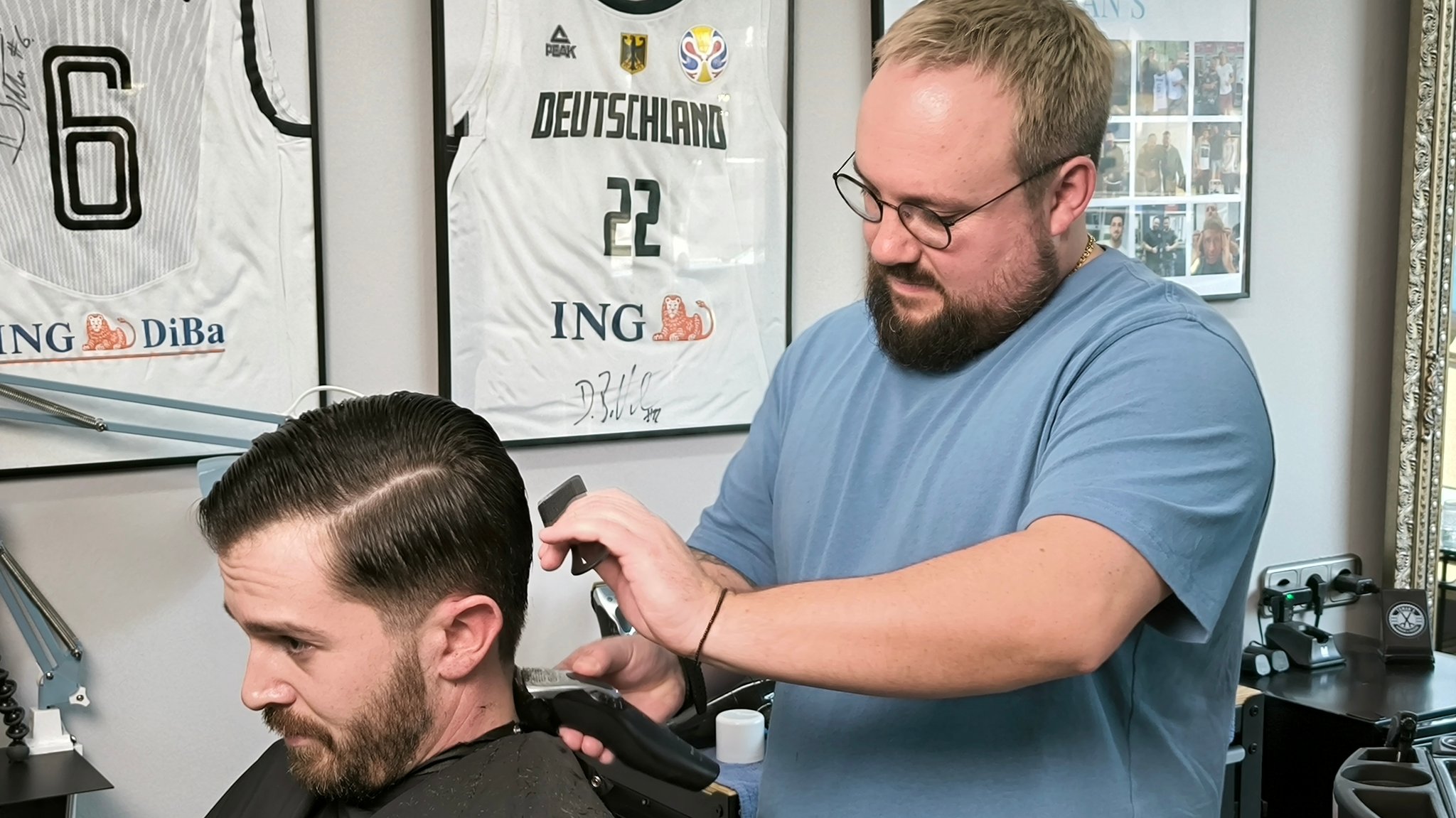 Ein Friseur rasiert einem Kunden die Nackenhaare