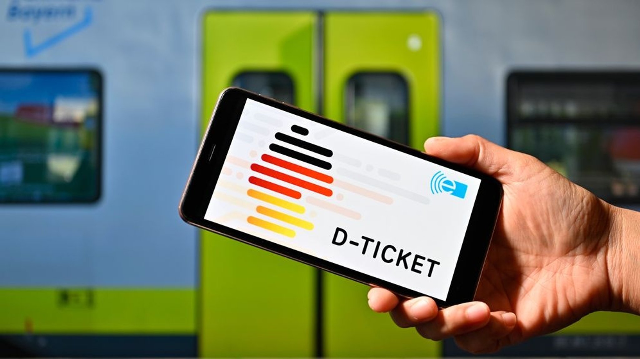 Eine Person hält ein Smartphone mit der Deutschlandticket-App. | Bildrechte: picture alliance / Panama Pictures | Dwi Anoraganingrum