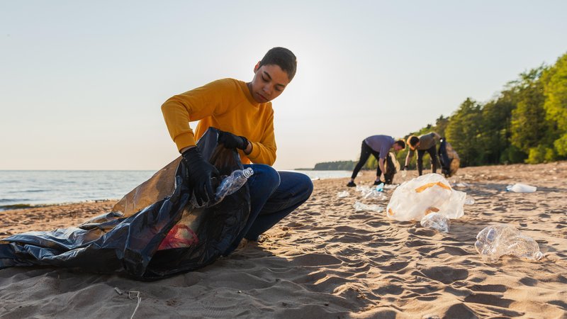 Jugendliche Freiwillige sammeln Plastik und anderen Müll am Strand ein. | Bild: picture alliance / Zoonar | Iuliia Zavalishina Jugendliche Freiwillige sammeln Plastik und anderen Müll am Strand ein.