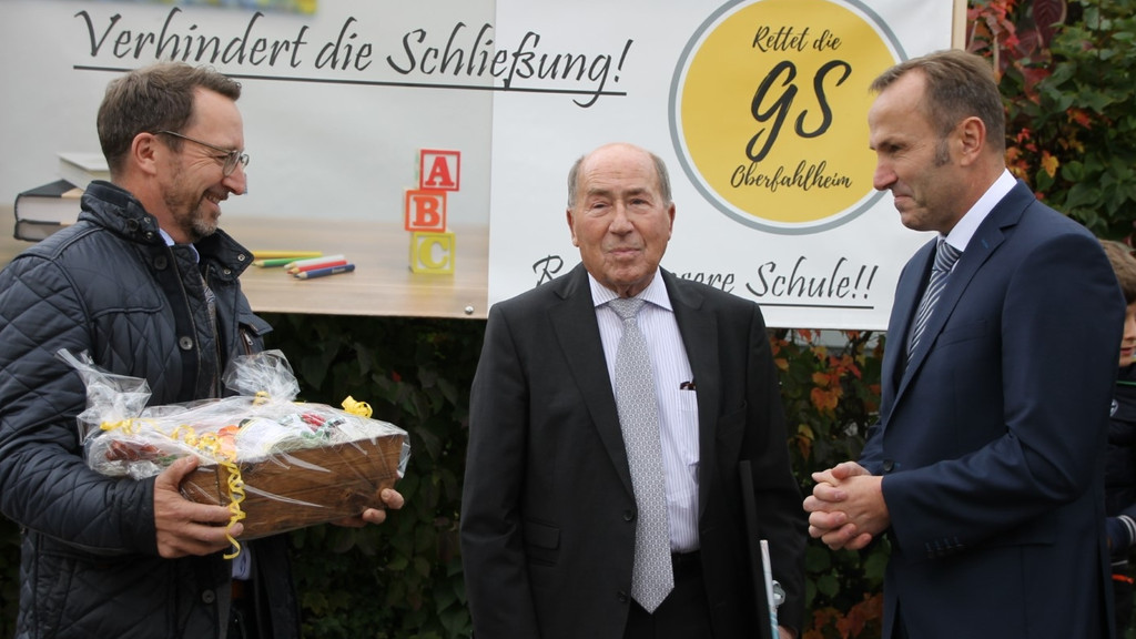 Erwin Müller, Benjamin Rix und Josef Maier stehen vor einem Plakat "Verhindert die Schulschließung"