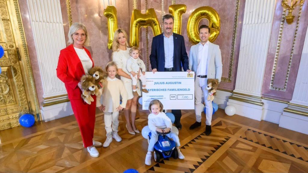 Archivbild: Im Oktober 2024 überreichten Sozialministerin Scharf und Ministerpräsident Söder der Familie des einmillionsten Kindes einen symbolischen Familiengeldscheck in Höhe von 7.200 Euro 