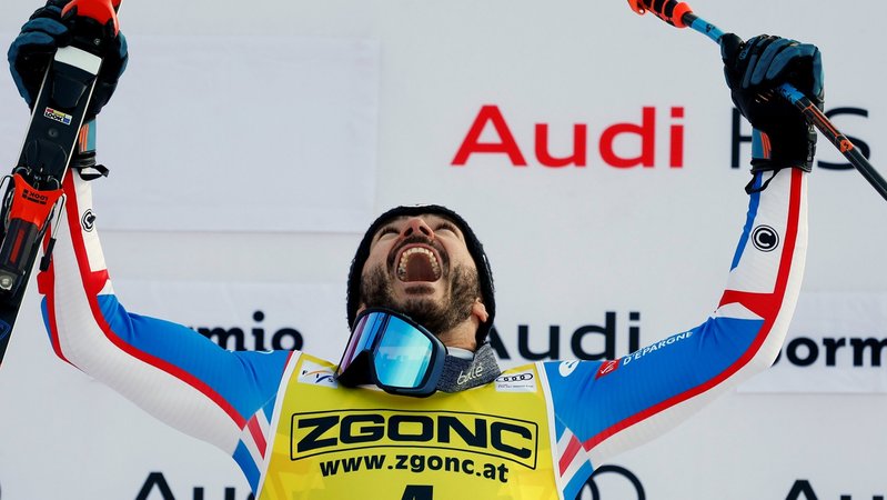 28.12.2023, Italien, Bormio: Ski alpin: Weltcup, Abfahrt, Herren: Cyprien Sarrazin jubelt auf dem Podium nach seinem Sieg.