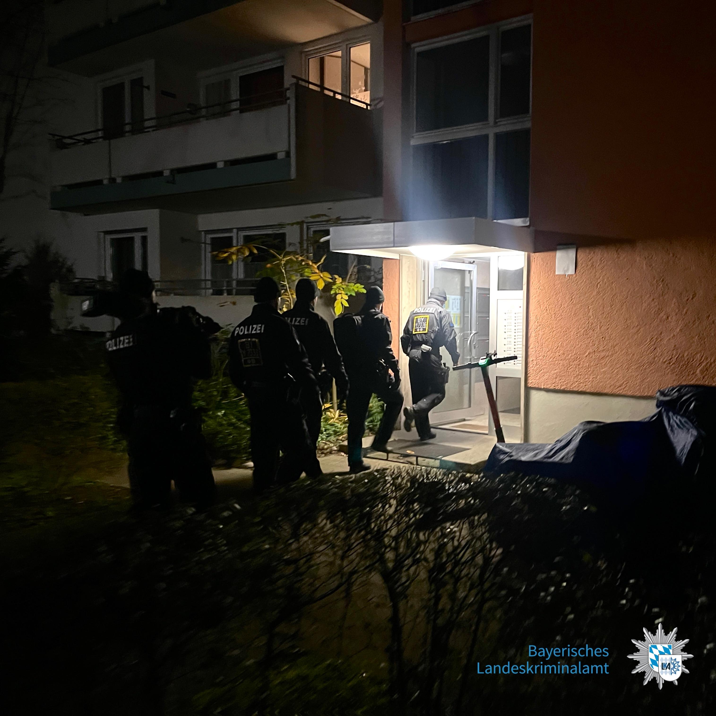Polizeibeamte betreten bei Dunkelheit ein Wohnhaus
