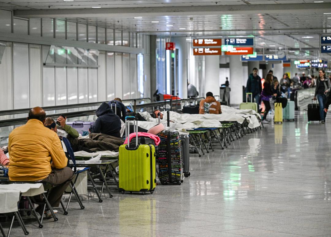 03.10.2025, Bayern, München: Menschen warten nach Drohnensichtungen und Flugausfällen in Flughafen München auf Feldbetten. Wegen Drohnensichtungen sind am Flughafen in München am Donnerstagabend rund 20 Flüge ausgefallen.