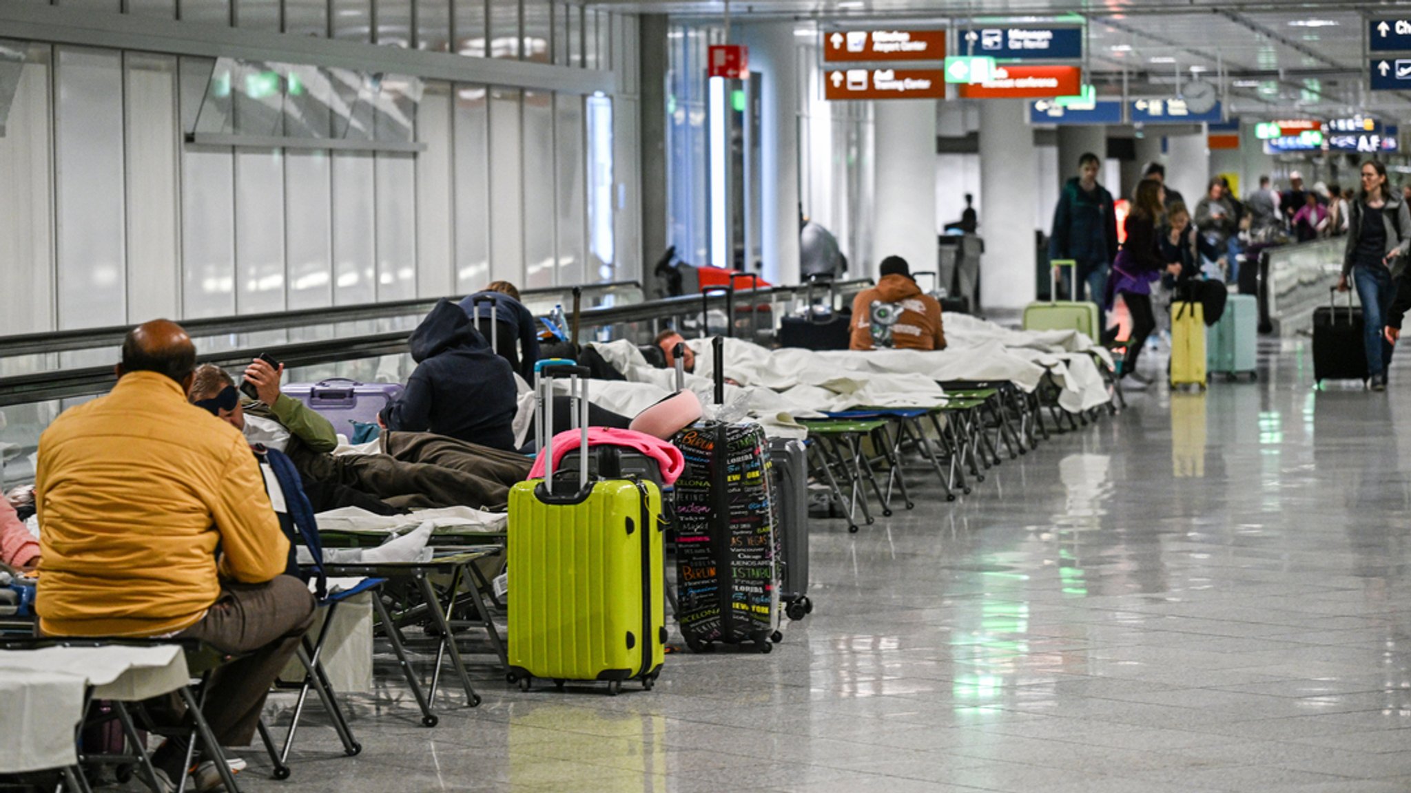 03.10.2025, Bayern, München: Menschen warten nach Drohnensichtungen und Flugausfällen in Flughafen München auf Feldbetten. Wegen Drohnensichtungen sind am Flughafen in München am Donnerstagabend rund 20 Flüge ausgefallen.