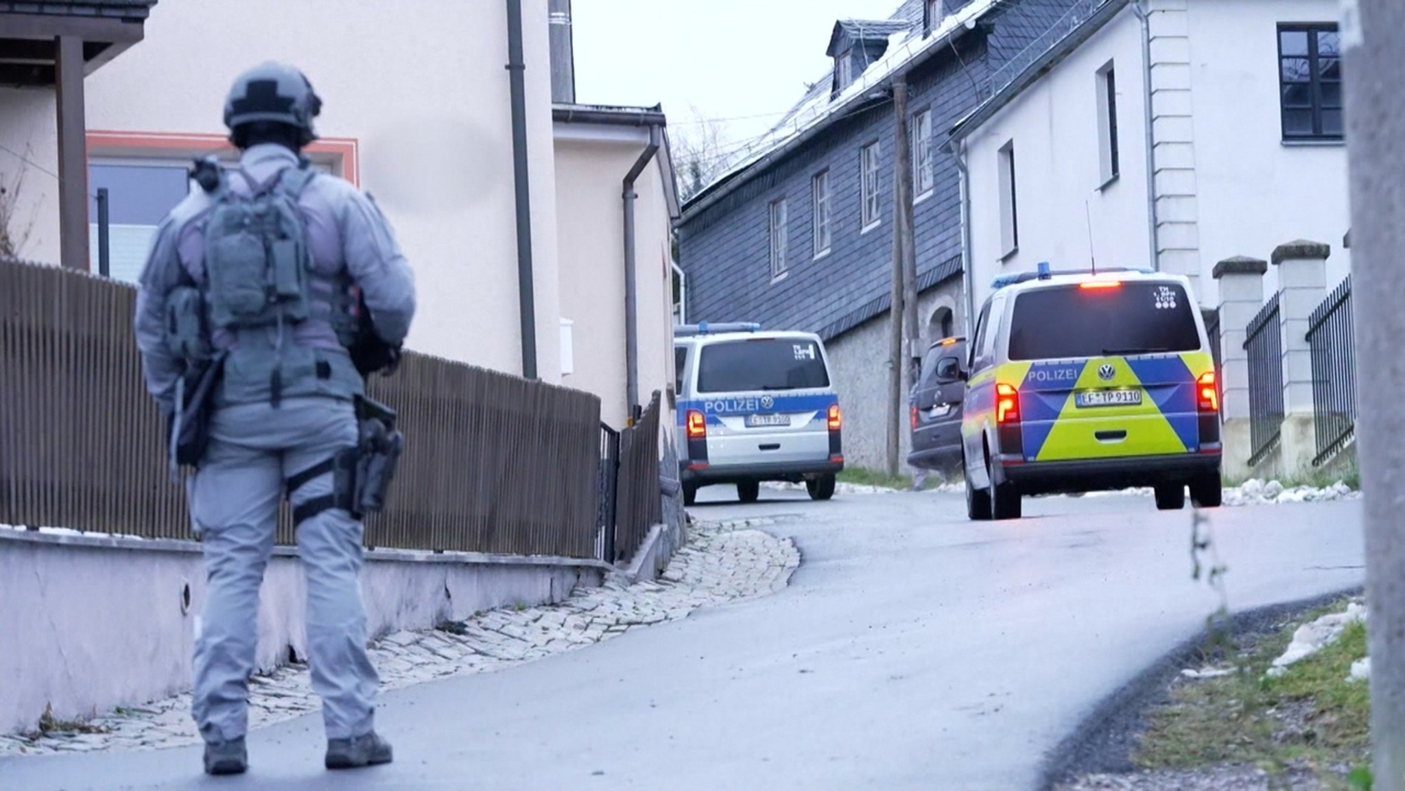 Ein Polizist und Polizeiautos bei der Razzia gegen Reichsbürger Anfang Dezember 2022