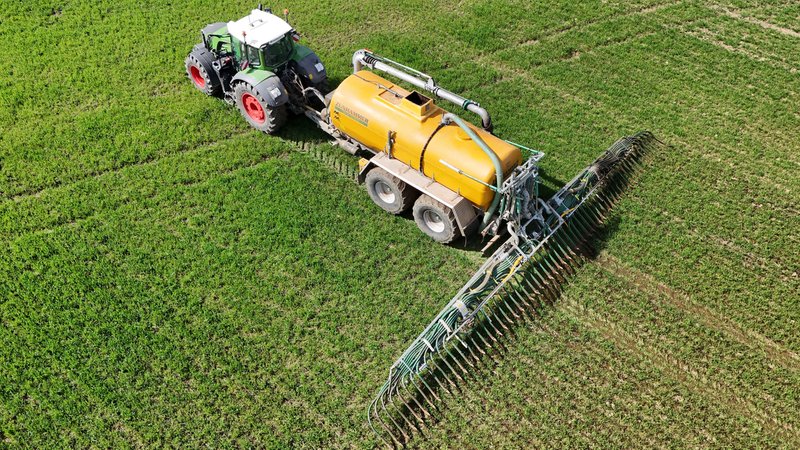 Ein Landwirt bringt Gülle mithilfe der Schleppschuhtechnik aus. | Bild: dpa / picture alliance Ein Landwirt bringt Gülle mithilfe der Schleppschuhtechnik aus.