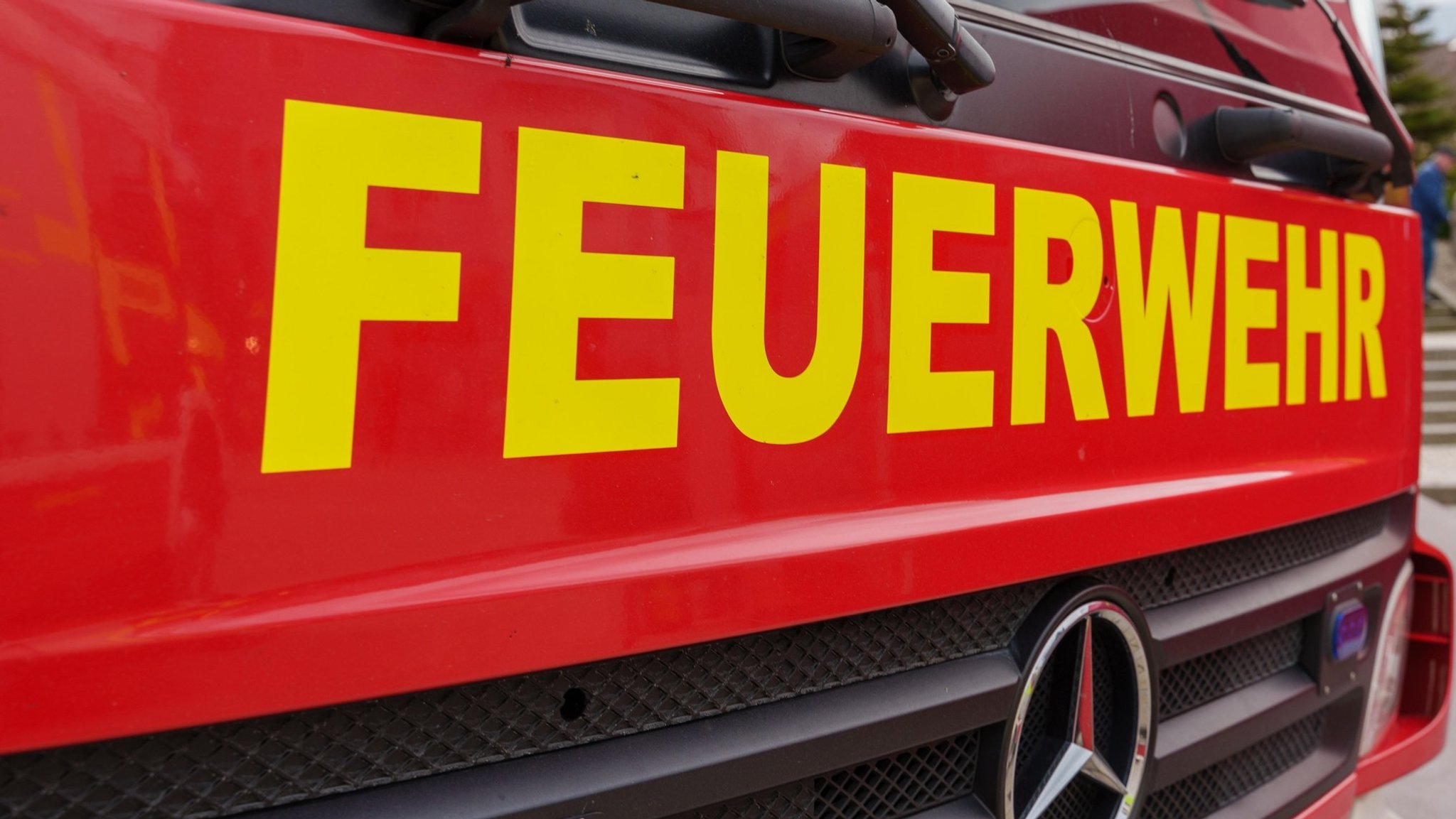 In gelber Schrift steht "Feuerwehr" auf der roten Frontseite eines Feuerwehrautos.