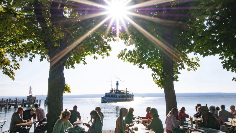 Menschen im Biergarten unter Kastanienbäumen in Herrsching am Ammersee. | Bild: picture alliance / imageBROKER | alimdi / Reinhold Ratzer Menschen im Biergarten unter Kastanienbäumen in Herrsching am Ammersee.
