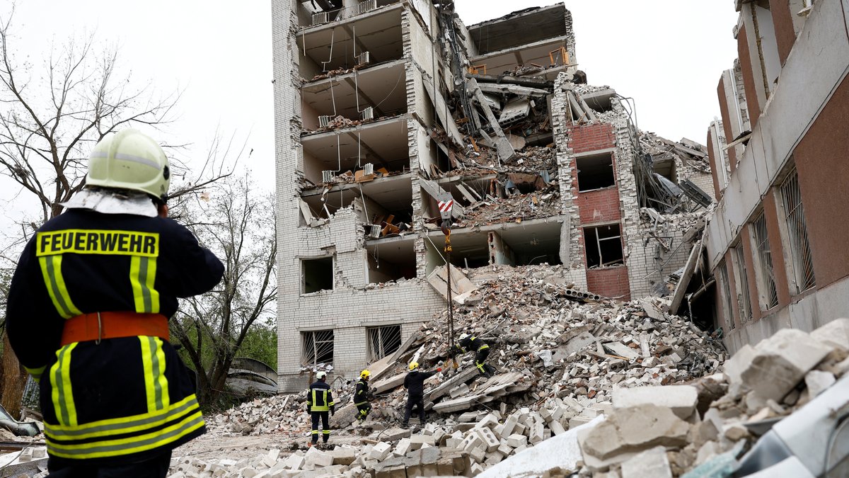 Rettungskräfte im Einsatz an einem zerstörten, mehrstöckigen Gebäude, dass bei dem russischen Raketenangriff auf Tschernihiw zerstört wurde