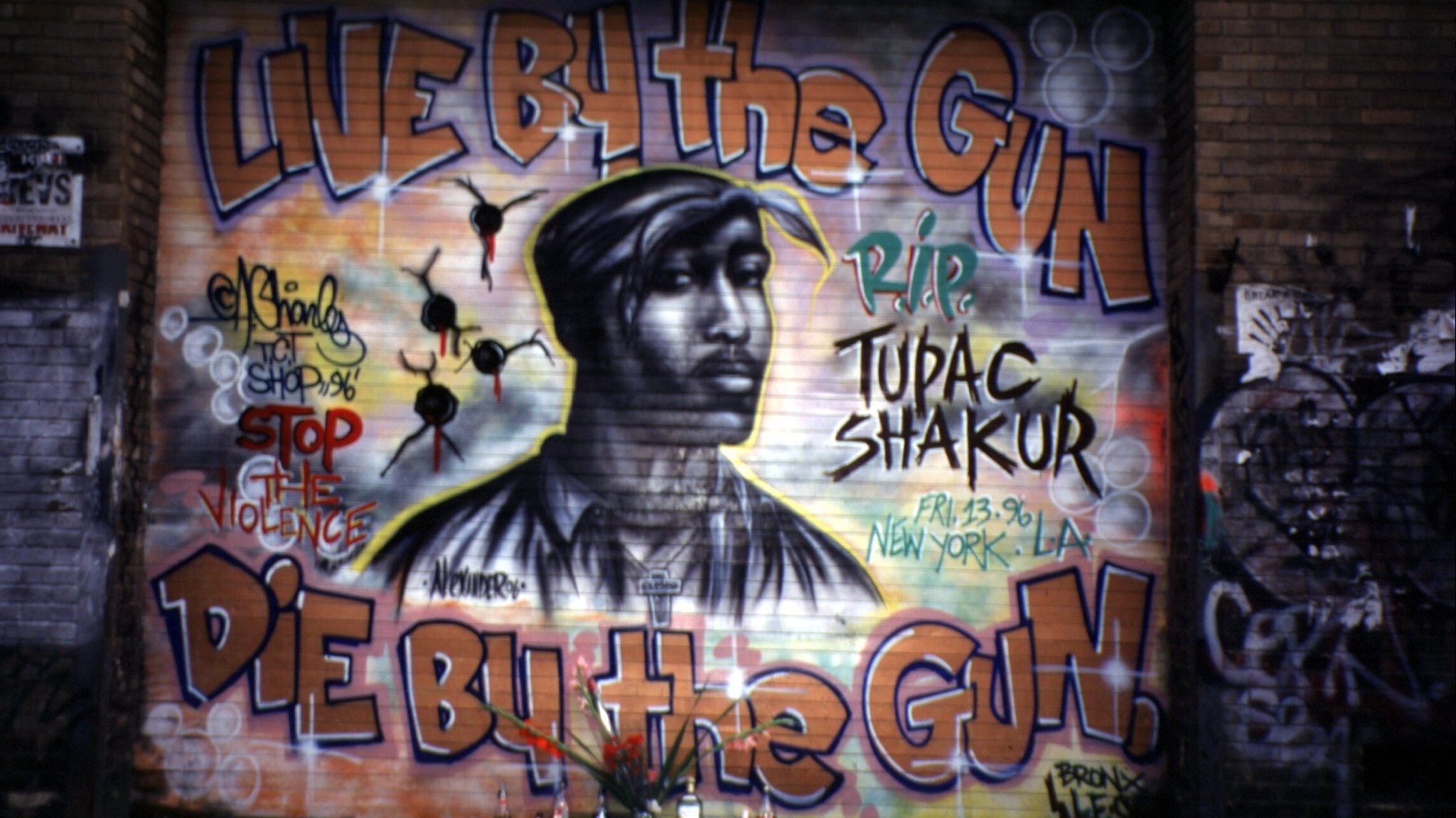 "Er lebte mit dem Gewehr - und starb durch ein Gewehr," steht über und unter dem Porträt des US-Rappers Tupac Shakur, das ein Graffiti-Künstler an eine Wand in New York gesprüht hat (Aufnahme vom 15.9.1996). Shakur war am 13.9.1996, eine Woche nach einem Mordanschlag, an den Folgen seiner Schußverletzung gestorben. | Bild: picture-alliance / dpa | Photoreporters "Er lebte mit dem Gewehr - und starb durch ein Gewehr," steht über und unter dem Porträt des US-Rappers Tupac Shakur, das ein Graffiti-Künstler an eine Wand in New York gesprüht hat (Aufnahme vom 15.9.1996). Shakur war am 13.9.1996, eine Woche nach einem Mordanschlag, an den Folgen seiner Schußverletzung gestorben.