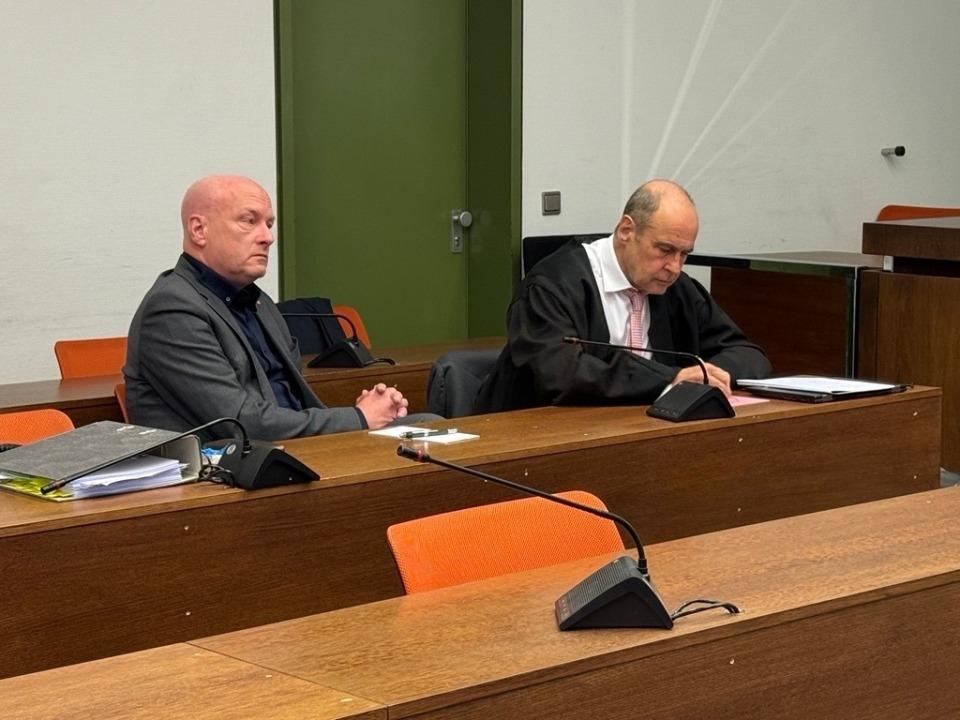 Zwei Männer sitzen in einem Gerichtssaal