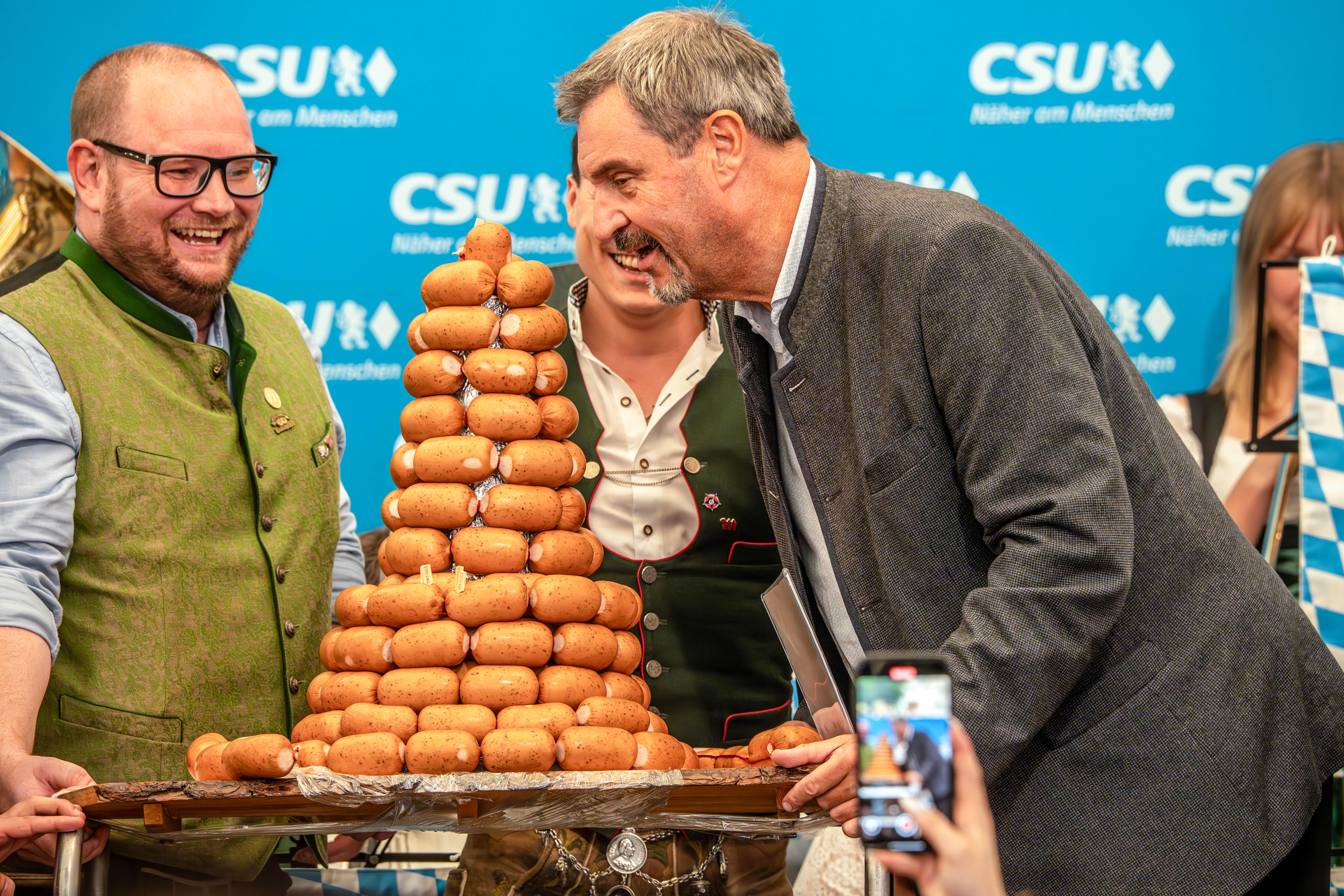 Markus Söder nimmt beim Frühschoppen der CSU München-West beim Aubinger Herbstfest eine kleine Aufmerksamkeit der bayerischen Metzgerinnung entgegen.