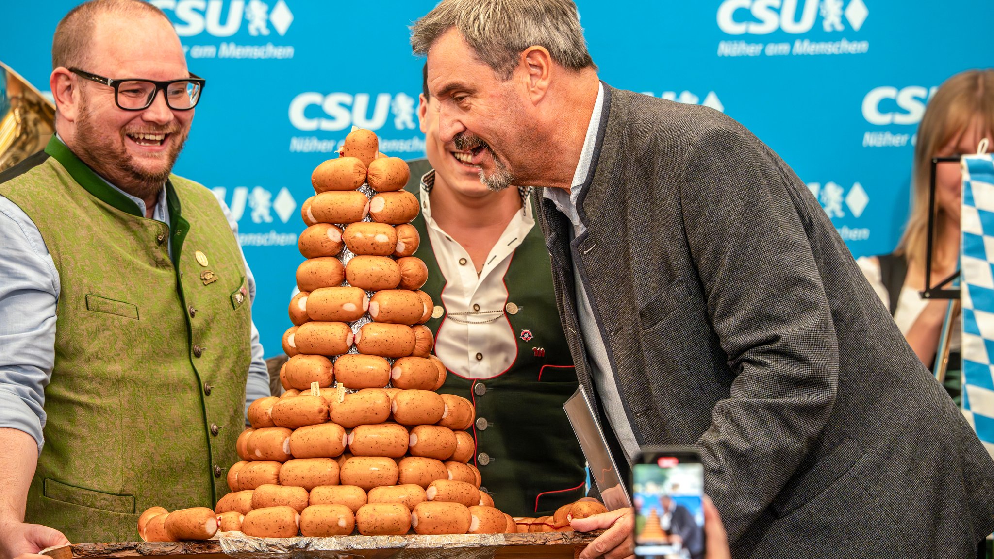 Markus Söder nimmt beim Frühschoppen der CSU München-West beim Aubinger Herbstfest eine kleine Aufmerksamkeit der bayerischen Metzgerinnung entgegen.
