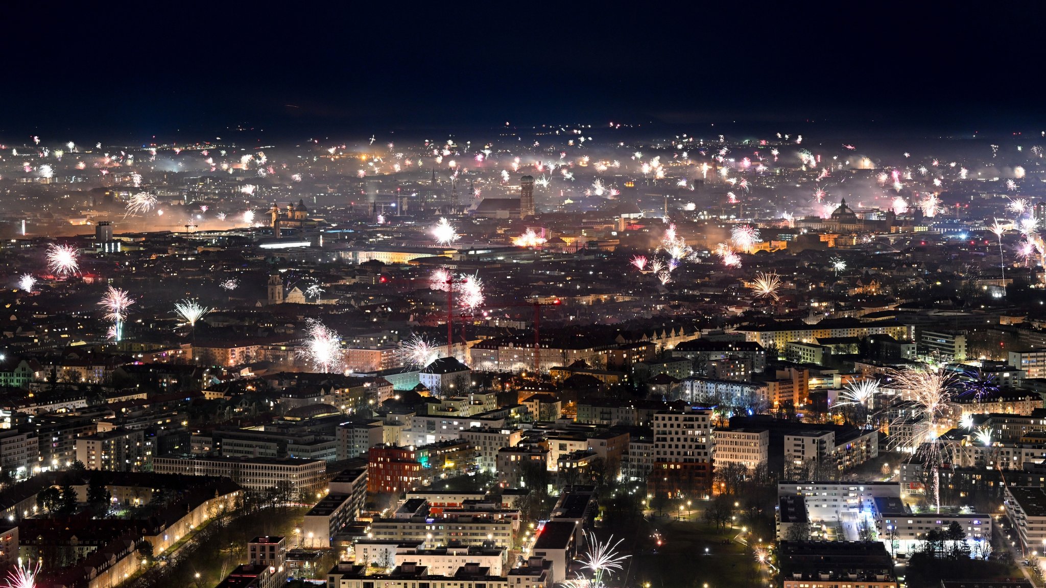 01.01.2024, München - Feuerwerk über der Landeshauptstadt, rund um die Frauenkirche explodieren Raketen und andere Feuerwerkskörper.