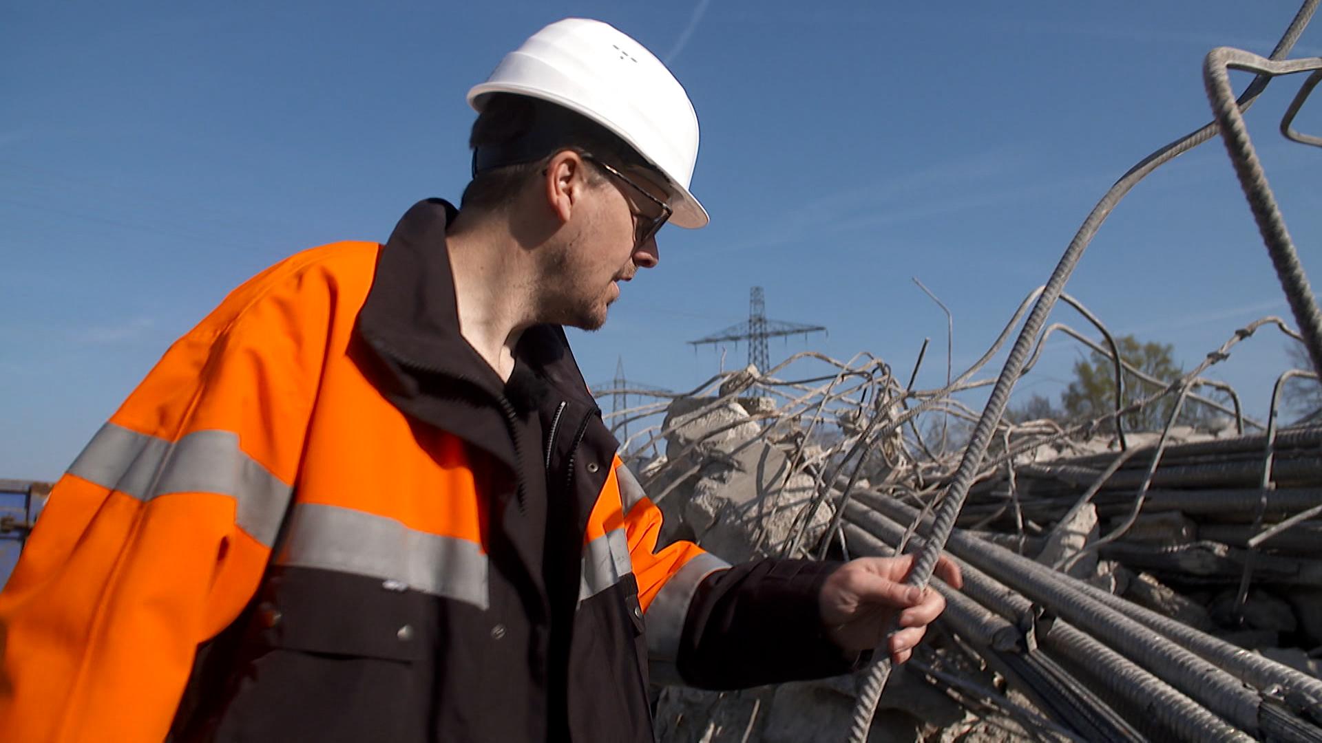 Ein Bauarbeiter untersucht den Stahl aus einer Brücke in Nürnberg.