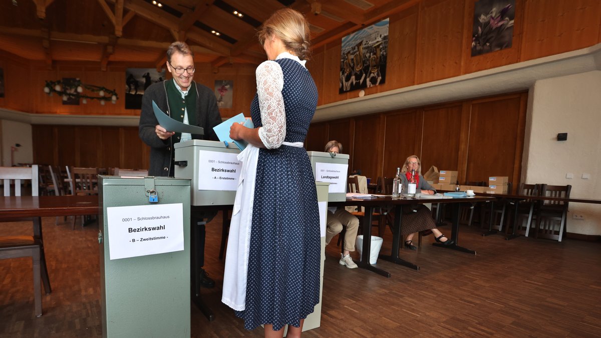 Eine Frau in einem bayerischen Dirndl gibt ihre Stimme ab.