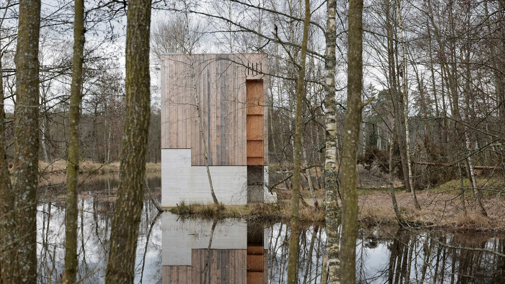 Außenansicht der Waldnaabkapelle bei Tirschenreuth in einem Wald am Teich: schmaler Holzbau