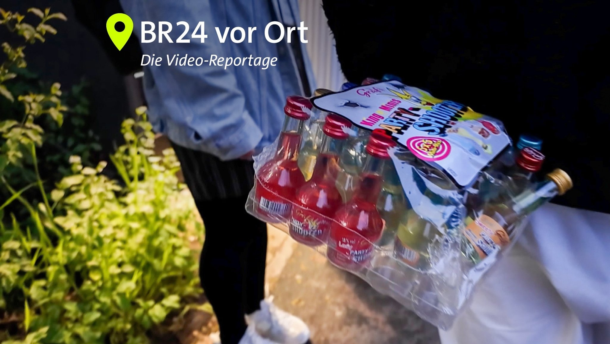 Jugendlicher hält kleine Schnapsflaschen hinter seinem Rücken