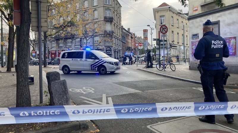 17.10.2023, Belgien, Brüssel: Die Polizei sperrt eine Straße, während ein Polizist hinter Absperrband Wache steht.
