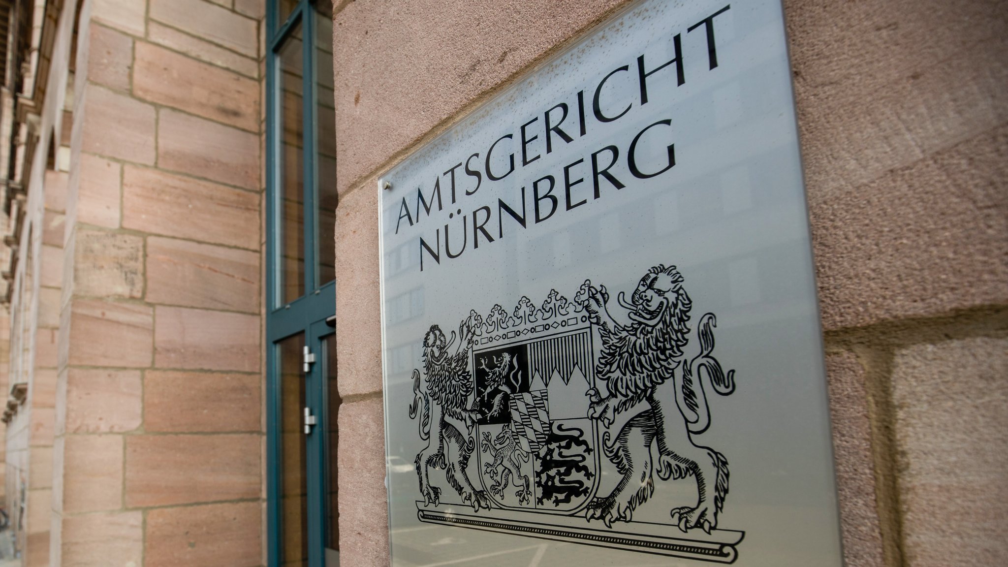 Ein Schild mit dem bayerischen Wappen und dem Schriftzug «Amtsgericht Nürnberg» hängt am Eingangsbereich des Amtsgerichts