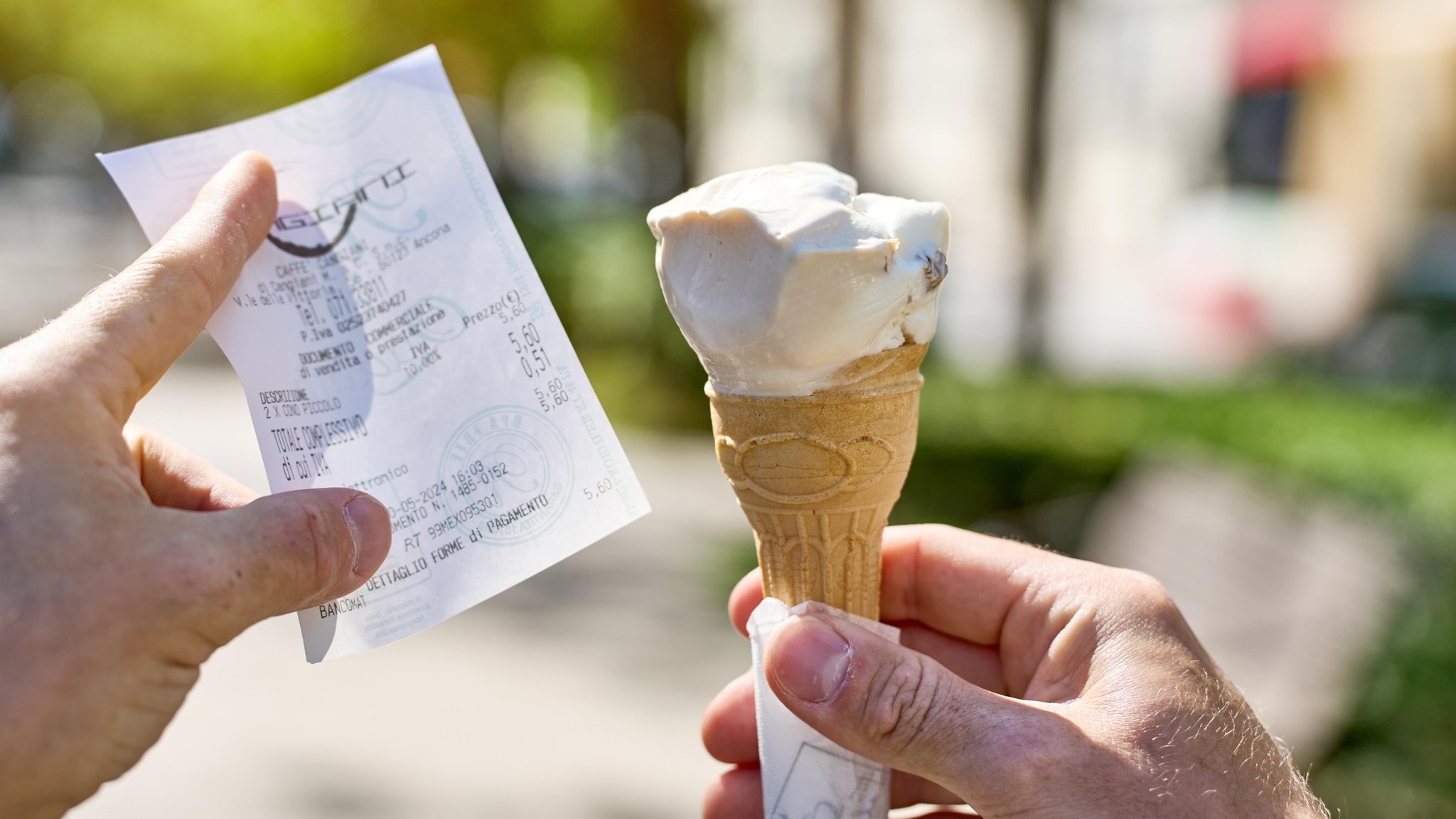 Ein Mann hält eine Waffel mit einer Kugel Eis im Sommer zusammen mit einem Kassenbon. (Symbolbild)