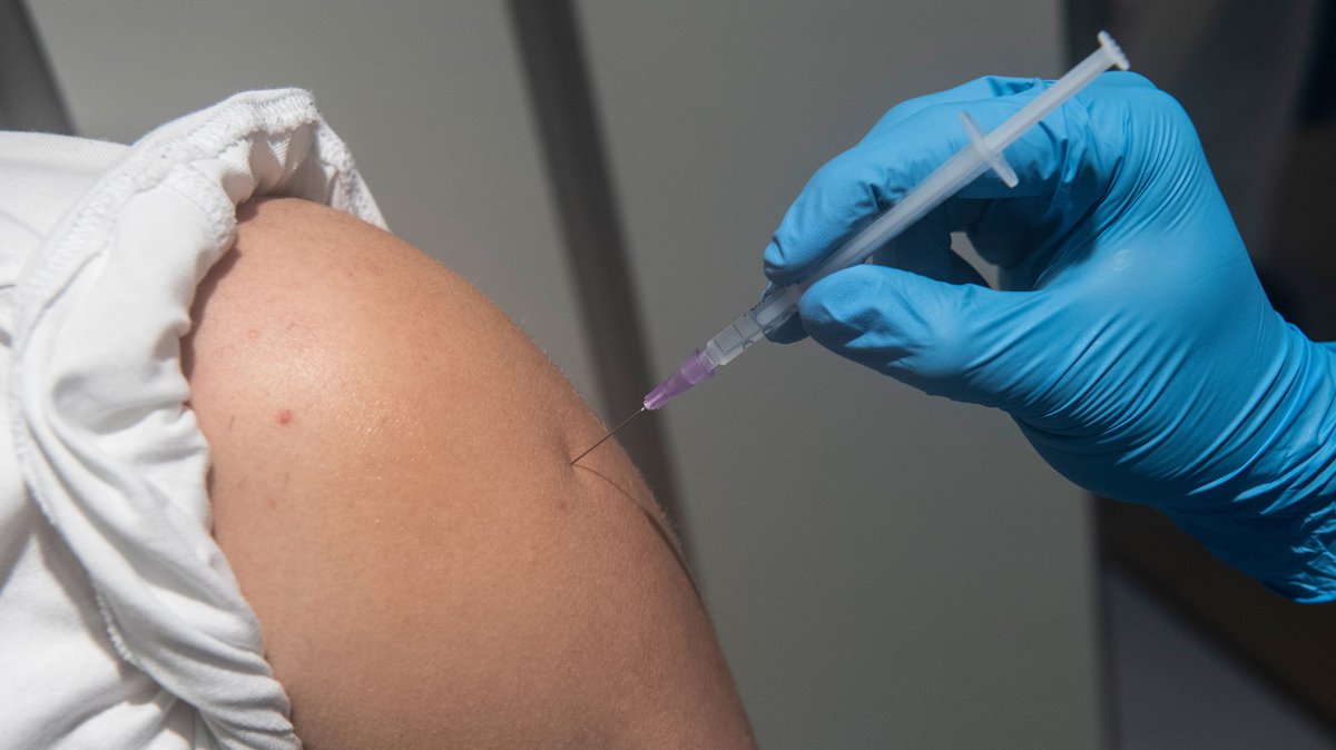 Ein Mitarbeiter eines Impfzentrums verabreicht eine Impfung gegen das Corona-Virus (Symbolbild)