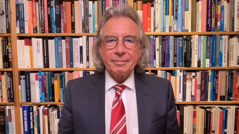 Ein Mann mit Brille, Anzug, Krawatte und längerem grauen Haar vor einer Bücherwand: Es ist Thomas Jäger, Professor für Internationale Politik und Außenpolitik