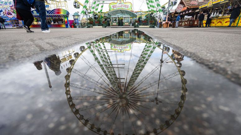 Stuttgart: Ein Riesenrad spiegelt sich in einer Pfütze auf dem Festgelände des Stuttgarter Frühlingsfestes | Bild:dpa-Bildfunk/Marijan Murat