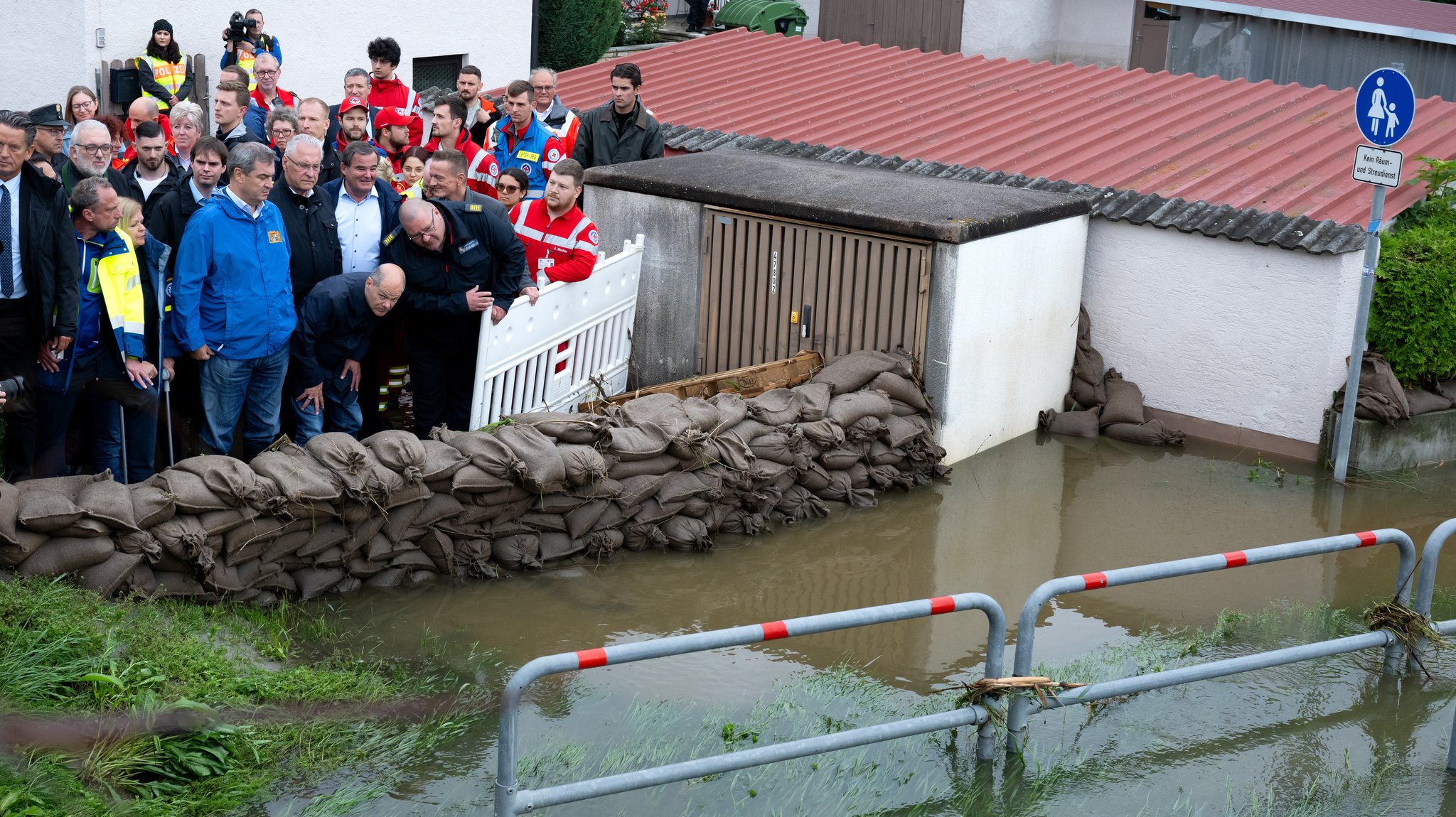 Bundeskanzler Olaf Scholz und Ministerpräsident Markus Söder stehen hinter eine Barriere aus Sandsäcken in Reichertshofen.