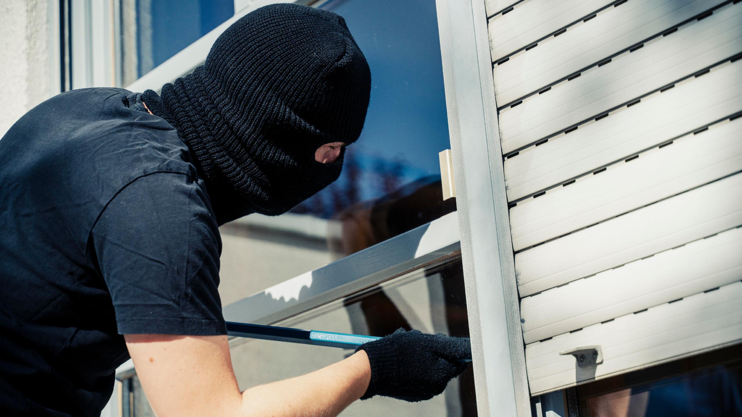Symbolbild: Einbrecher hebelt ein Fenster auf