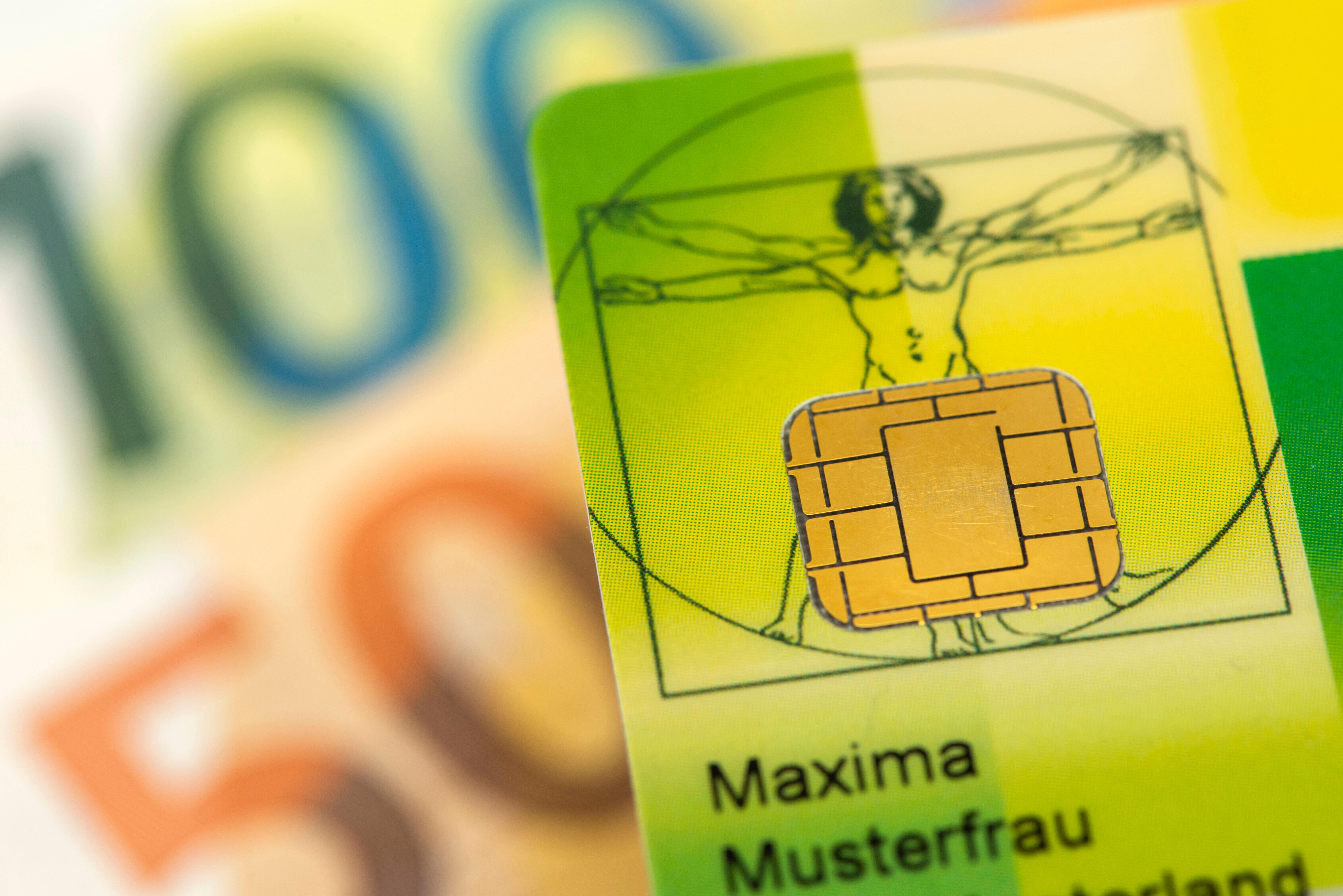 Eine Gesundheitskarte liegt über Euro Banknoten.