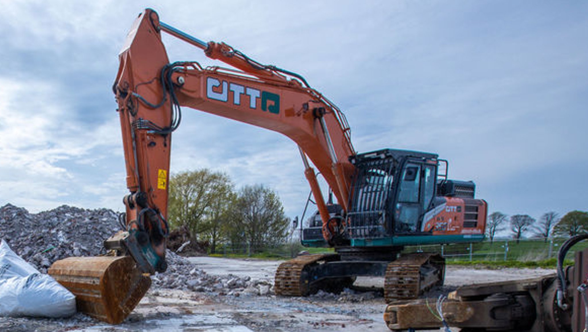 Ein Bagger bearbeitet Bauschutt 